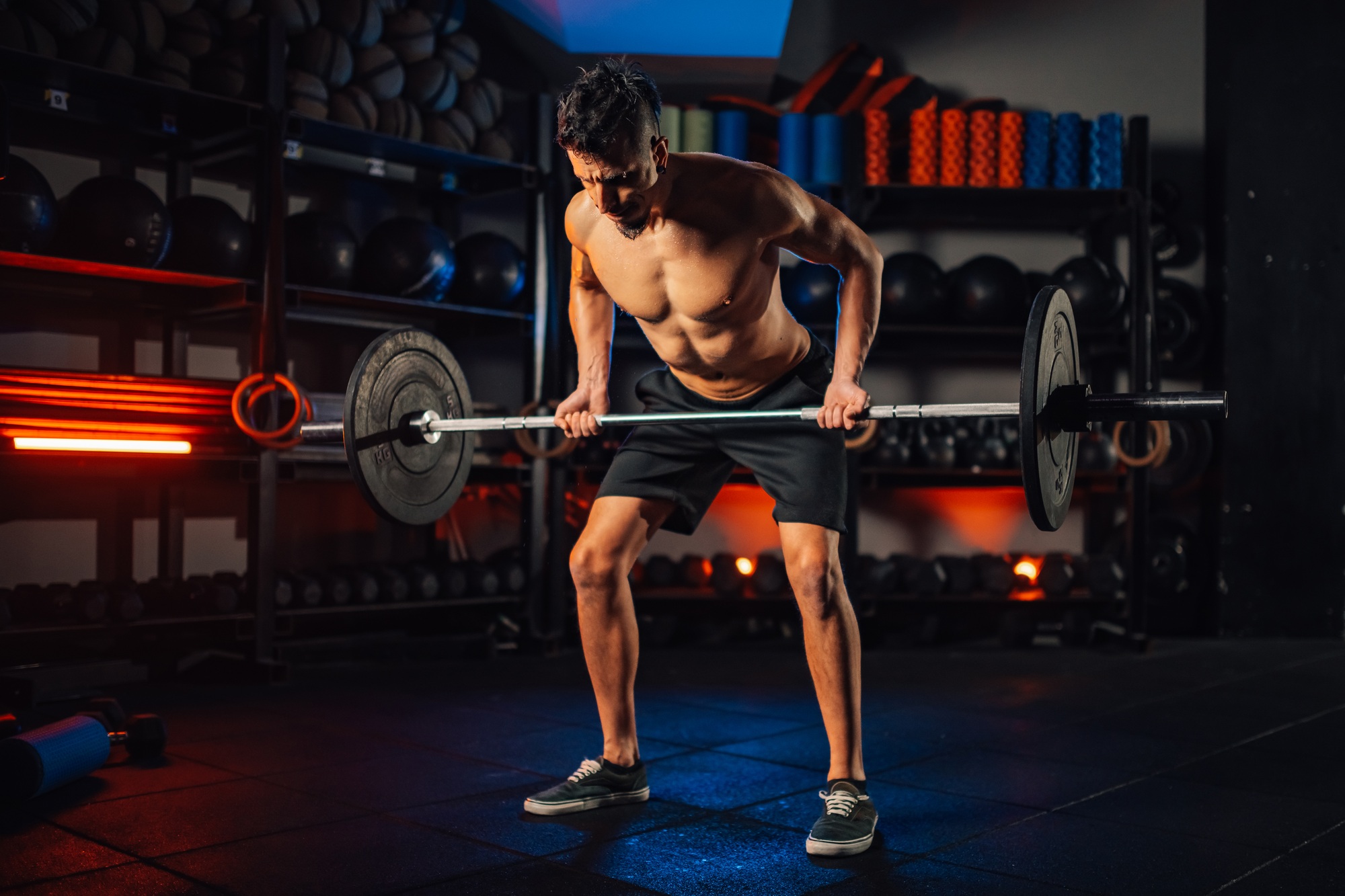 Weightlifting man training in a gym while lifting heavy weights